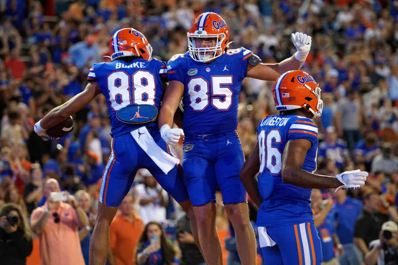 Florida Gators players wearing blue and orange jerseys celebrating enthusiastically after scoring a touchdown, displaying team spirit and showing the joy of successful plays during the game.
