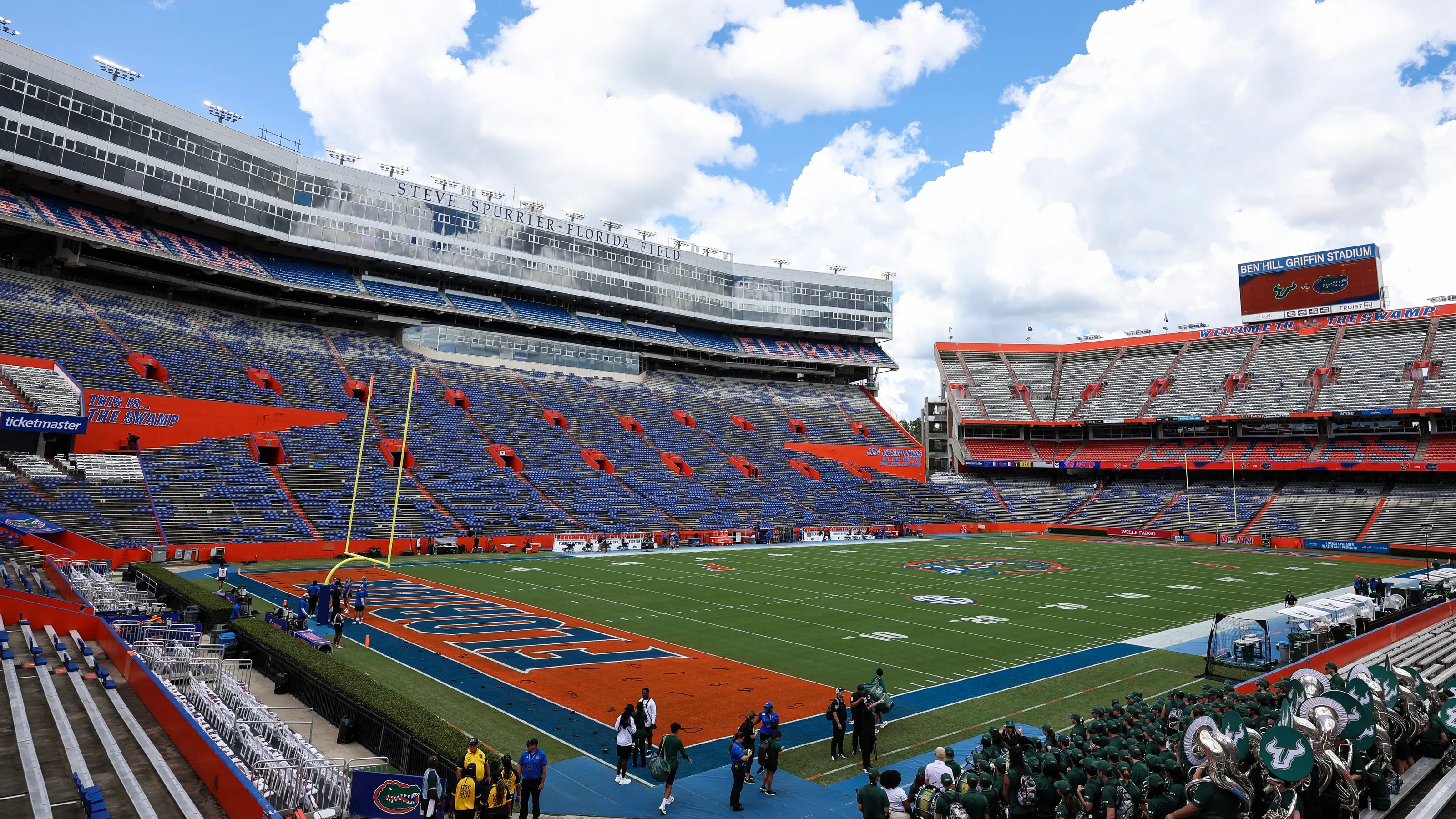Ben Hill Griffin Stadium, known as The Swamp, in Gainesville, Florida on game day with thousands of Gators supporters wearing blue and orange filling the stands. The historic venue is filled to capacity with passionate fans creating an intense home-field atmosphere.