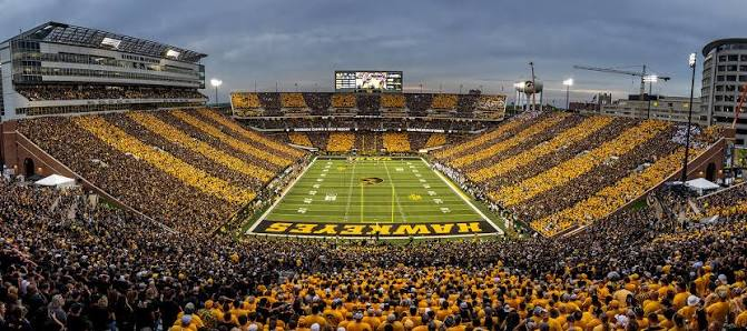 Kinnick Stadium in Iowa City packed with thousands of supporters in gold and black creating a sea of color