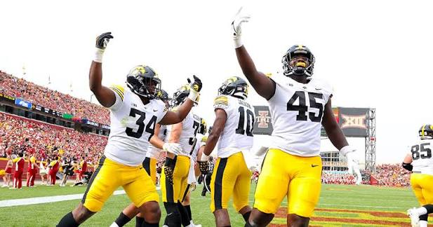 Iowa players celebrating a touchdown with arms raised in celebration