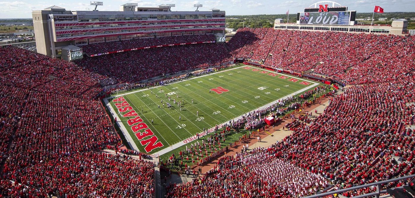 Aerial view of Memorial Stadium in Lincoln, packed with supporters dressed in red, during a Nebraska home game