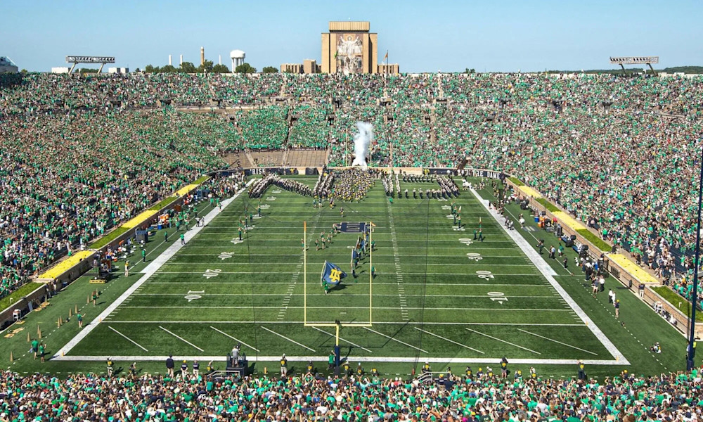 Notre Dame Stadium packed with thousands of supporters in green and gold with the Golden Dome visible
