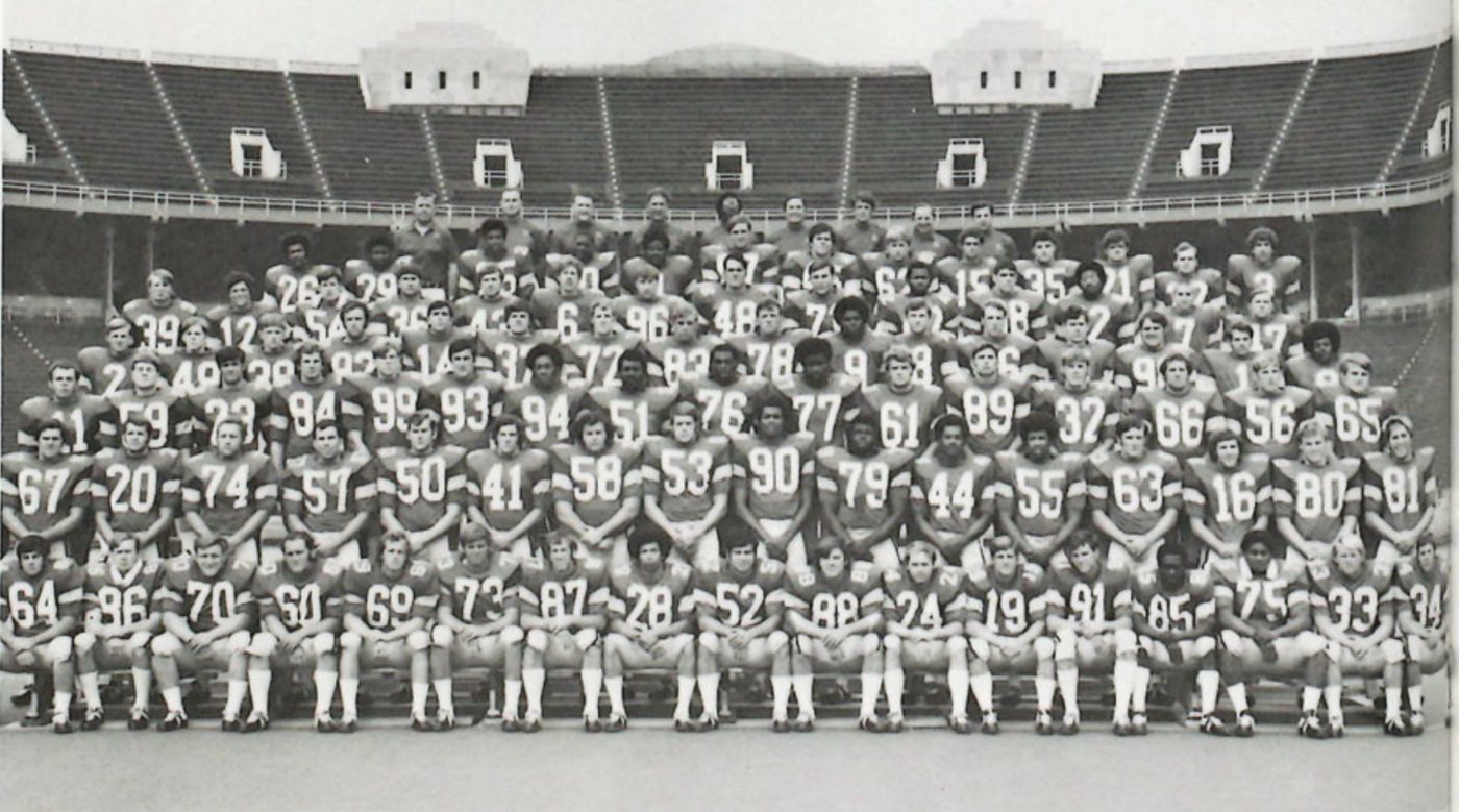 Black and white photograph of a full Ohio State squad in numbered jerseys, arranged in rows on the field inside the empty bowl of Ohio Stadium