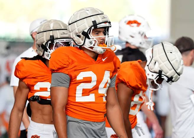 Oklahoma State Cowboys players gathered in a huddle