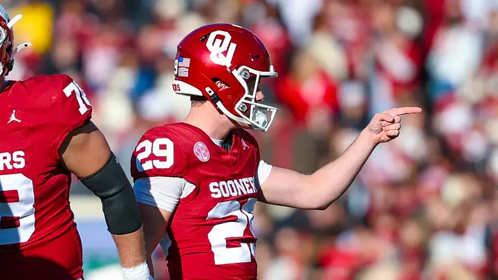 Oklahoma Sooners player in crimson jersey pointing during game action