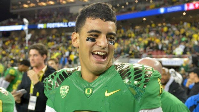 An Oregon player in a green jersey smiling during a conference championship celebration