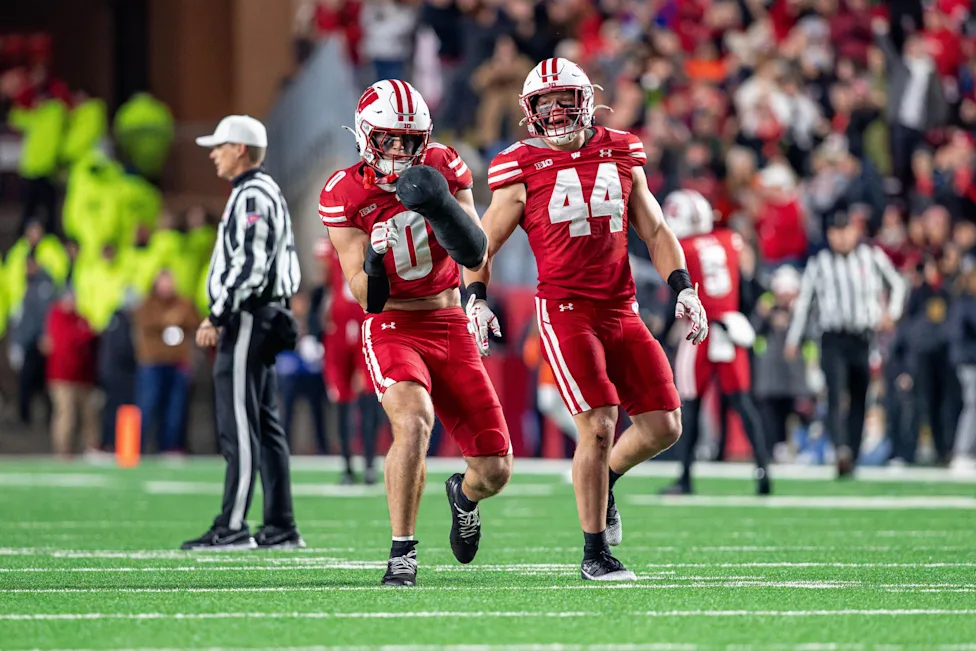Wisconsin Badgers players in red jerseys running during game action